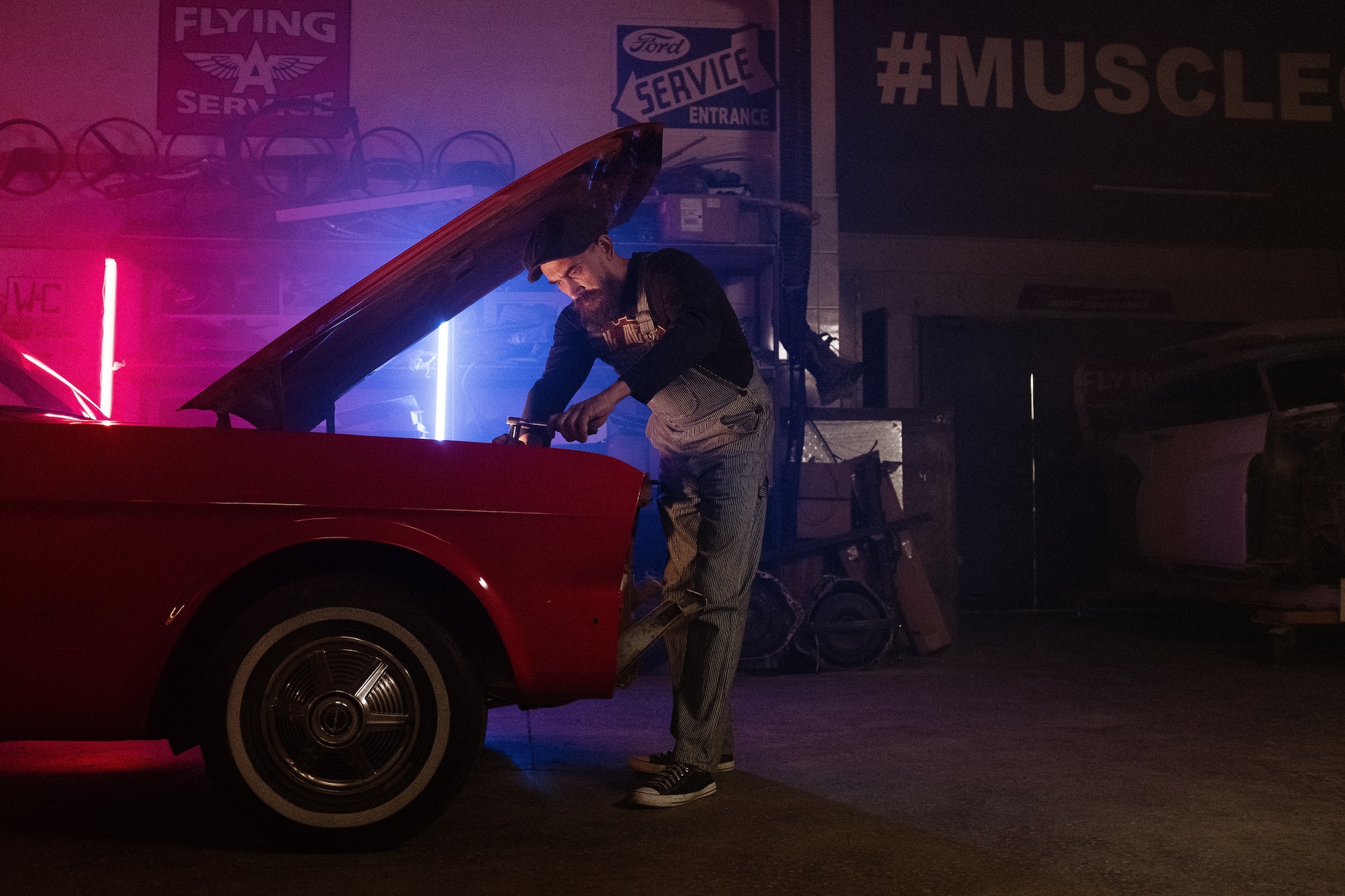 a mechanic standing next to a car with its hood open